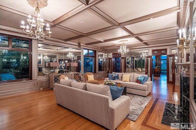 living room featuring coffered ceiling, a chandelier, and wood finished floors