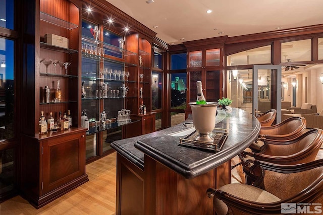 bar featuring recessed lighting, light wood-style floors, and bar area