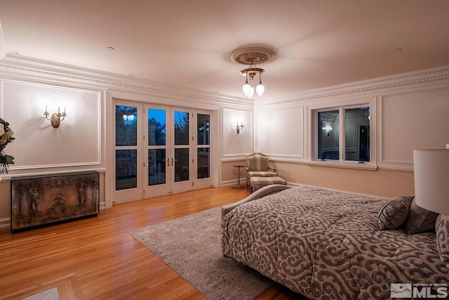 bedroom featuring crown molding, wood finished floors, and french doors