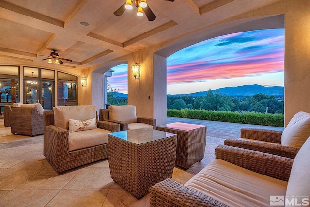 view of patio / terrace with an outdoor living space, a mountain view, and a ceiling fan
