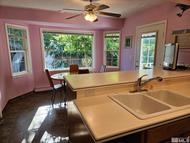 kitchen featuring baseboard heating, ceiling fan, and sink