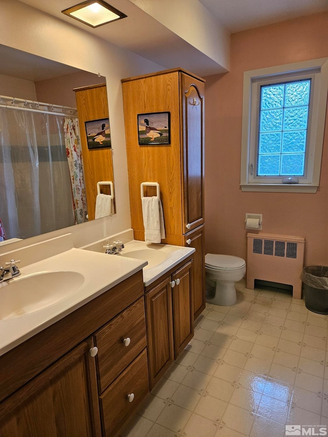 bathroom with radiator, vanity, and toilet