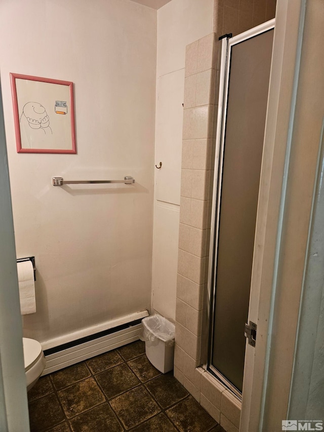 bathroom with toilet, a shower with door, and baseboard heating