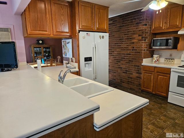 kitchen with white appliances, sink, ceiling fan, brick wall, and extractor fan