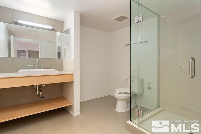bathroom with tile patterned floors, sink, a shower with door, and toilet
