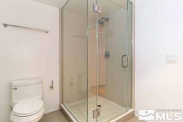 bathroom with walk in shower, tile patterned flooring, and toilet