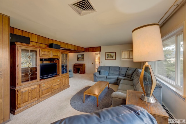 carpeted living room with wood walls and a baseboard radiator