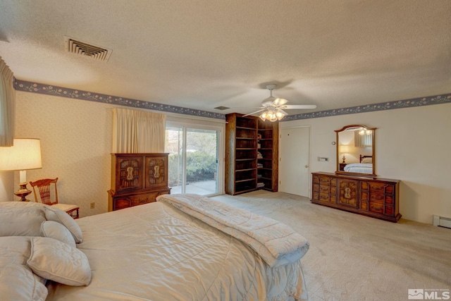 bedroom with ceiling fan, access to outside, a textured ceiling, and carpet flooring