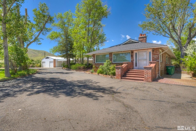 single story home featuring a garage and an outbuilding