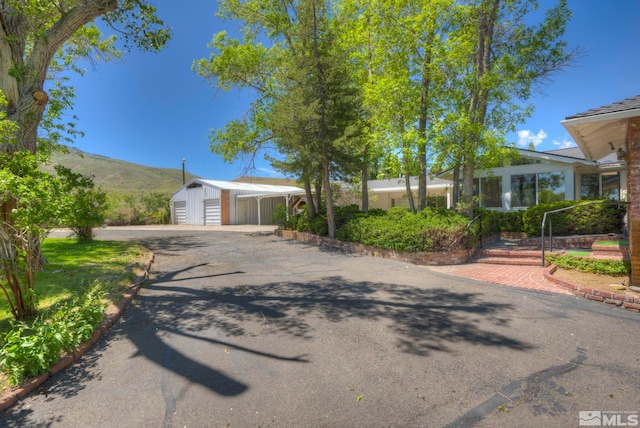 view of front of house featuring a mountain view, a garage, and a shed