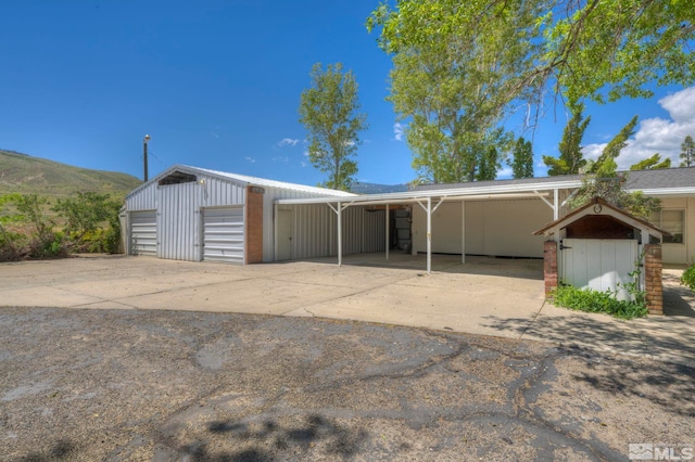 single story home with an outbuilding, a carport, a garage, and a mountain view