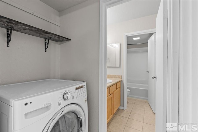 laundry room featuring washer / dryer and light tile patterned floors