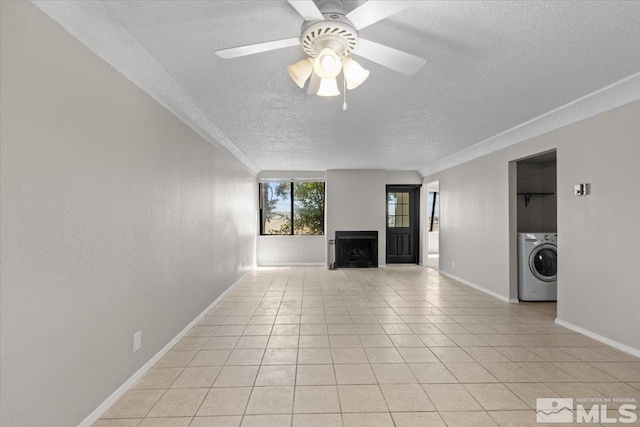 unfurnished living room with ceiling fan, light tile patterned floors, and washer / clothes dryer