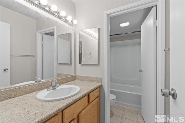 bathroom featuring tile patterned floors, vanity, and toilet