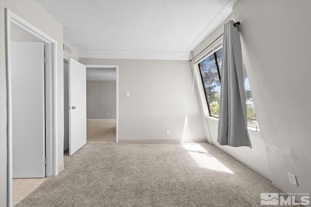 carpeted empty room featuring a textured ceiling