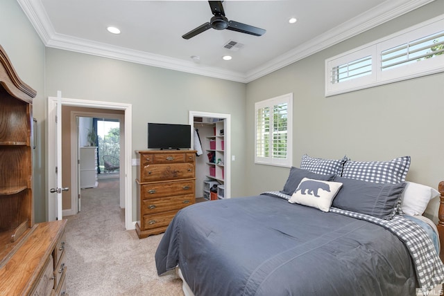 carpeted bedroom with ceiling fan, a walk in closet, crown molding, and a closet