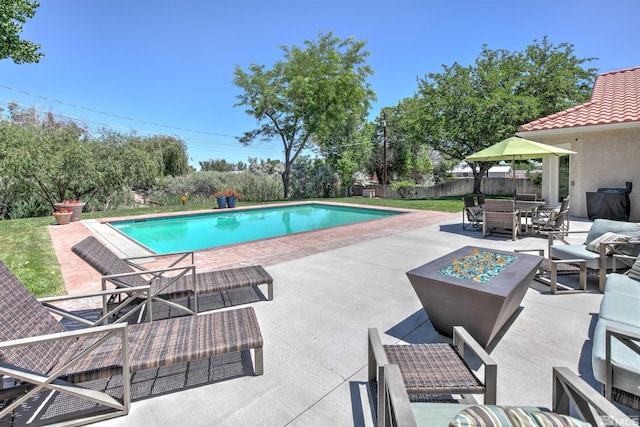 view of swimming pool featuring an outdoor living space with a fire pit and a patio