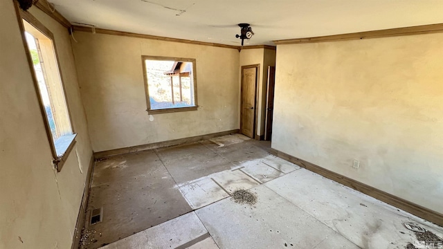 unfurnished room featuring crown molding and a healthy amount of sunlight