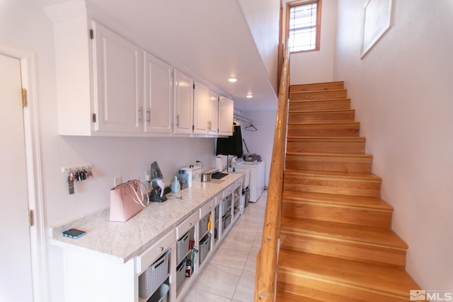 staircase with washing machine and dryer and tile patterned floors