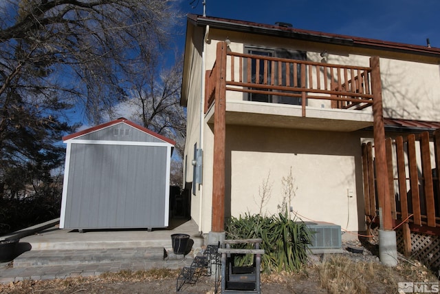 back of house featuring a balcony, a storage unit, and central air condition unit