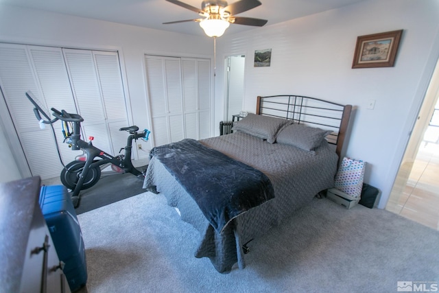 carpeted bedroom featuring two closets and ceiling fan