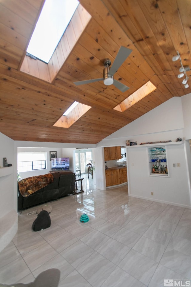 unfurnished living room featuring ceiling fan, lofted ceiling with skylight, and wood ceiling