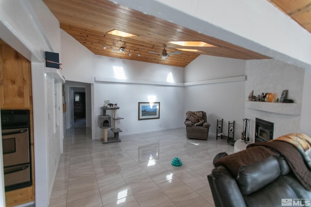 tiled living room featuring high vaulted ceiling, a skylight, ceiling fan, and wood ceiling