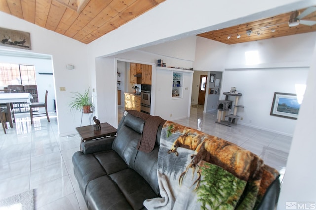 living room with light tile patterned floors, ceiling fan, lofted ceiling with skylight, and wooden ceiling