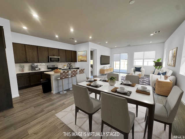 dining space with wood-type flooring and sink