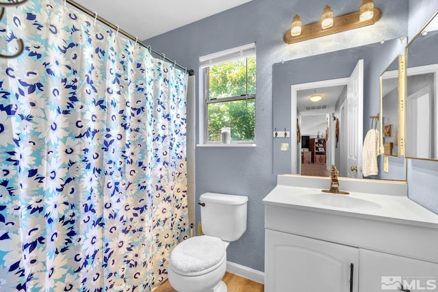 bathroom featuring curtained shower, vanity, hardwood / wood-style flooring, and toilet