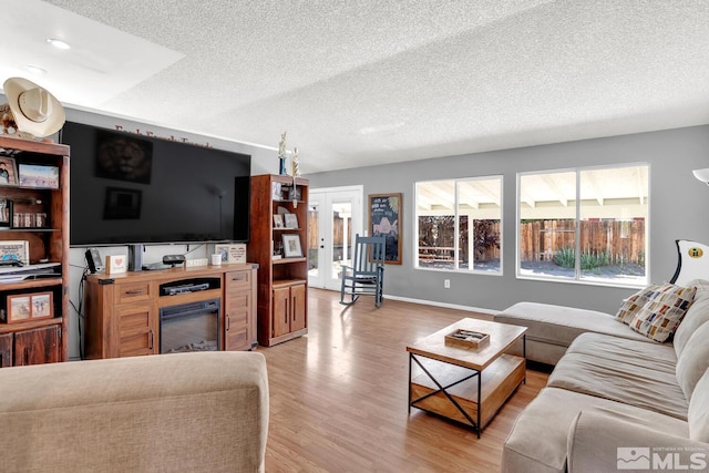 living room with light hardwood / wood-style floors and a textured ceiling