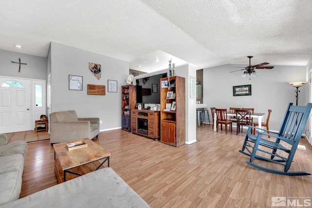 living room featuring hardwood / wood-style floors, a textured ceiling, and ceiling fan