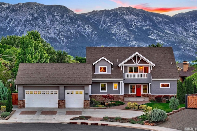 craftsman-style house with a mountain view, a balcony, and a garage