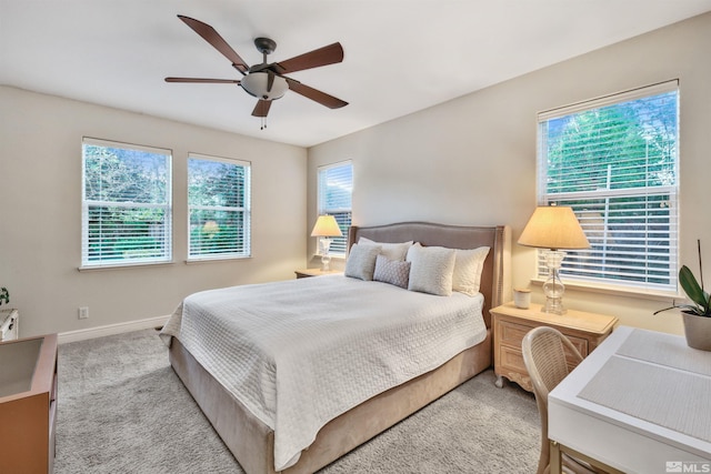 carpeted bedroom with multiple windows and ceiling fan