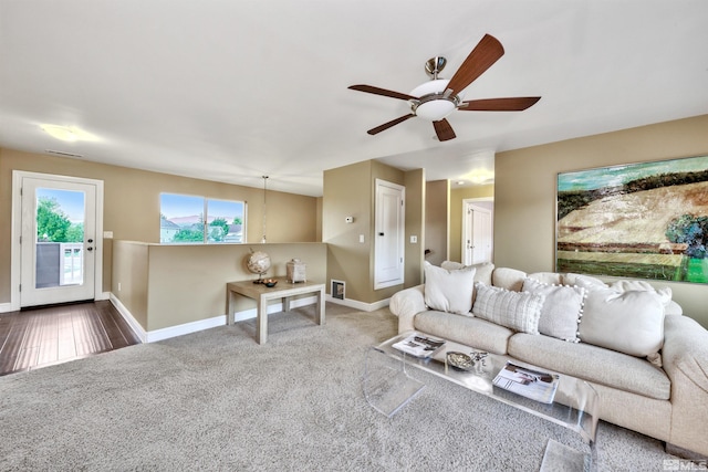 carpeted living room with ceiling fan