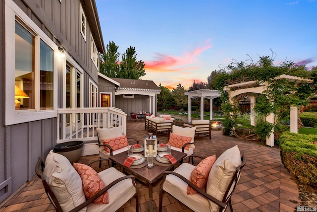 patio terrace at dusk with a pergola and outdoor lounge area