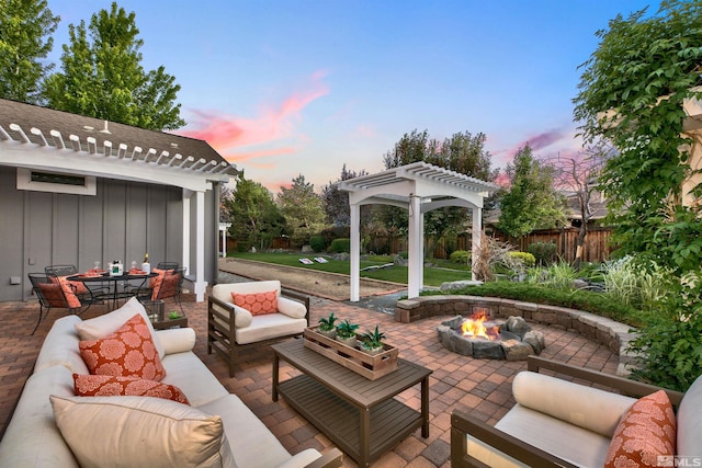 patio terrace at dusk featuring a pergola and an outdoor living space with a fire pit