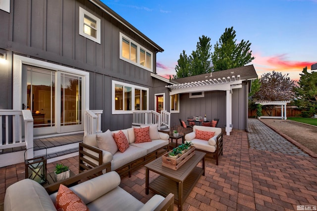 patio terrace at dusk featuring a pergola and an outdoor hangout area