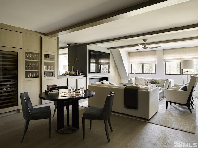 dining area featuring hardwood / wood-style flooring, ceiling fan, beam ceiling, and wine cooler