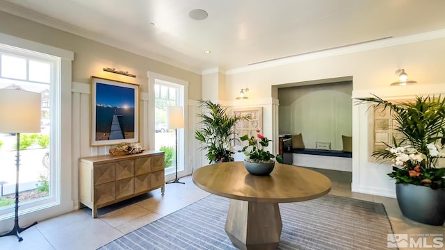 interior space with ornamental molding and light tile patterned floors