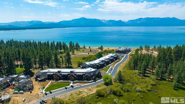 drone / aerial view featuring a water and mountain view