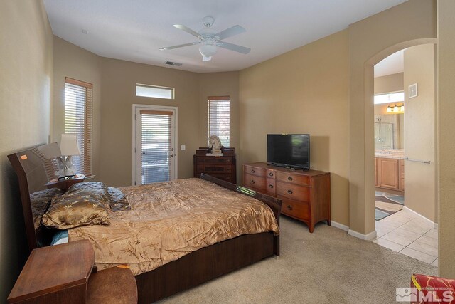 carpeted bedroom with ensuite bathroom and ceiling fan