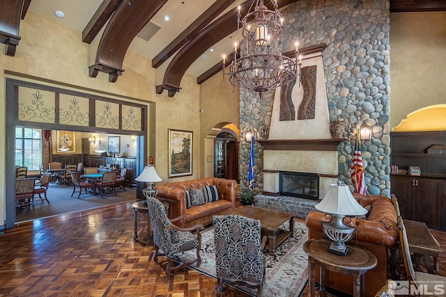 living room with parquet flooring, a fireplace, high vaulted ceiling, and an inviting chandelier