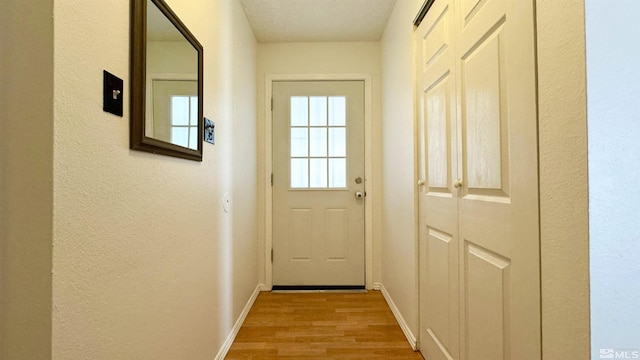 entryway with a textured ceiling and light hardwood / wood-style flooring