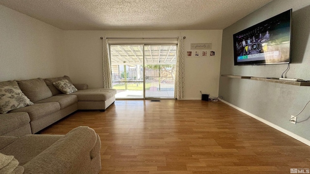 living room featuring wood-type flooring and a textured ceiling