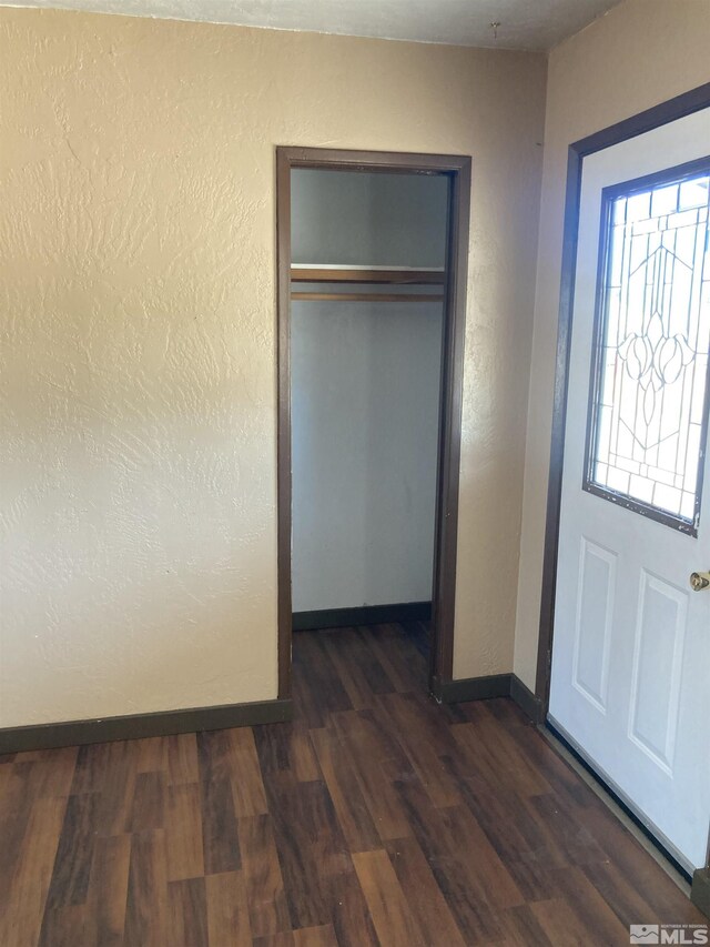 unfurnished bedroom featuring a closet and dark hardwood / wood-style floors