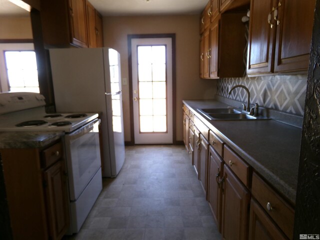 kitchen featuring white range with electric cooktop, sink, and plenty of natural light