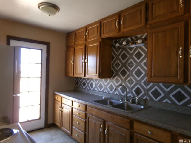 kitchen with backsplash, sink, plenty of natural light, and white refrigerator