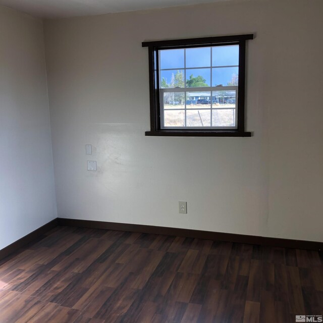 unfurnished room with dark wood-type flooring