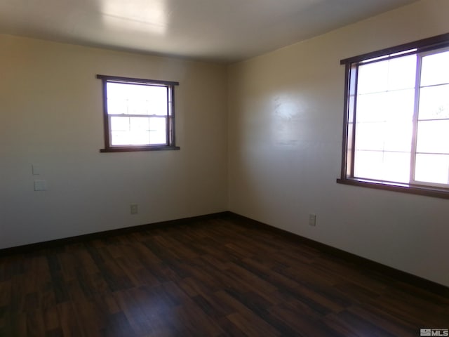 unfurnished room with dark wood-style floors and baseboards